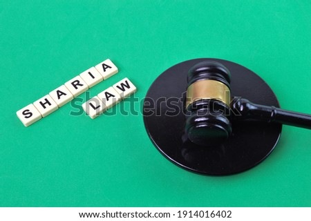 Selective focus of judge gavel and scrabble letters with text SHARIA LAW.