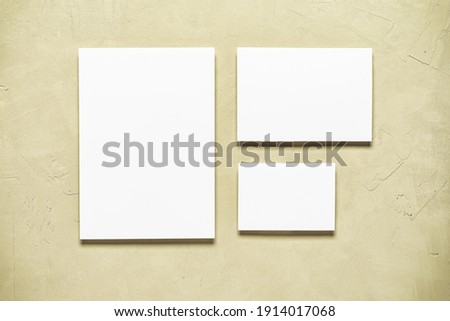Blank paper white cards mockup on beige concrete background. Modern stationery scene. Template for your design. Top view, flat lay
