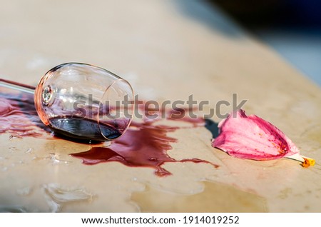 Glass of red wine drop on table, vintage style 
