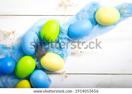Creative Easter photo. Easter eggs of different colors on a blue fabric runner.