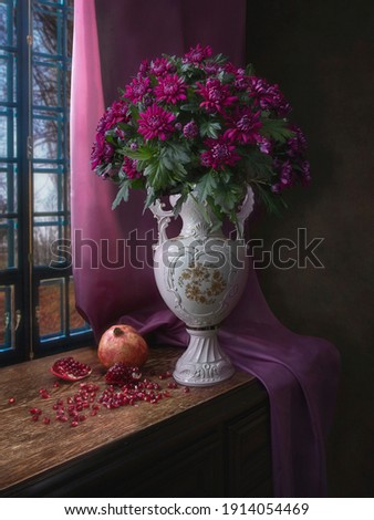 Still life with pomegranate and bouquet of chrysanthemum