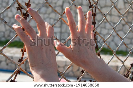 A woman trying to cross barbed wire