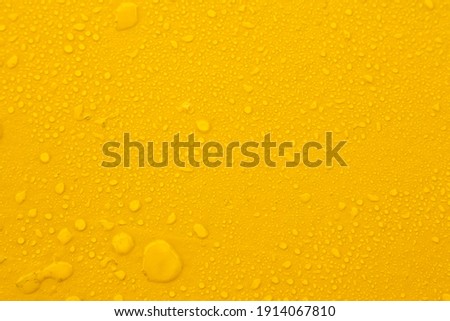 Water drops on a yellow background. Royalty-Free Stock Photo #1914067810
