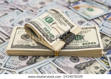 Stack of dollars and dollars with a metal clip on the money background. Lots of bills. Royalty-Free Stock Photo #1914078109