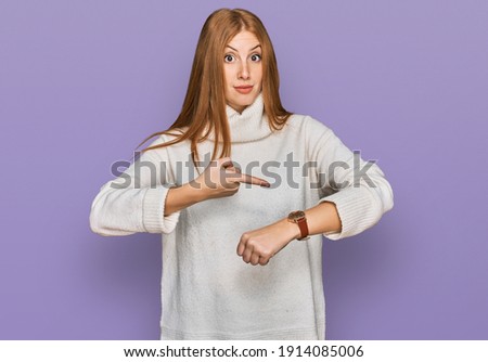 Young irish woman wearing casual winter sweater in hurry pointing to watch time, impatience, upset and angry for deadline delay 