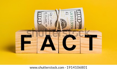 FACT with money on a yellow background. The concept of business, finance, credit, income, savings, investments, exchange, tax
