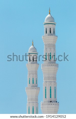 Close up the minarets of the Hazrat Sultan Mosque. Islamic religious architectural traditions. Mosque architecture. Kazakhstan, Central Asia. Isolated on blue background. Royalty-Free Stock Photo #1914129052
