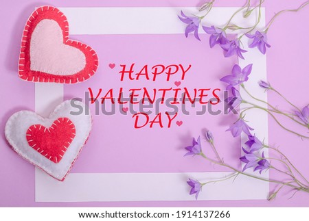 Greeting card with the inscription Happy Valentines Day, in a frame on a lilac background with hearts and flowers bells