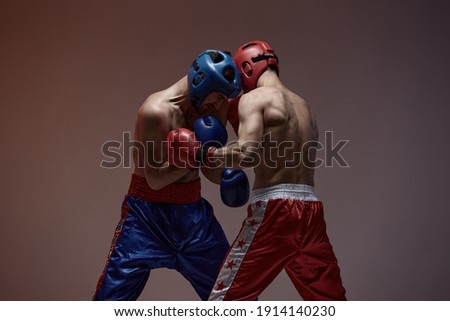 Wrestling of fighting athletic males boxers in studio, martial arts, mixed fight workout