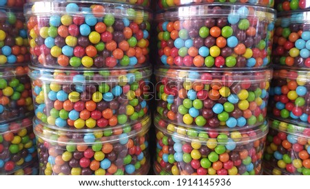 Various and colorful chocolate balls in jars displayed at the shop