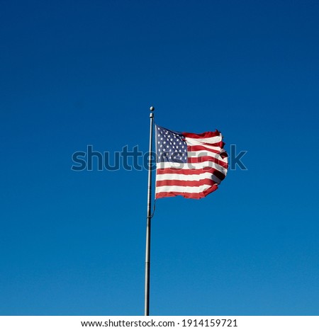 The american flag with a bright blue sky in the background.