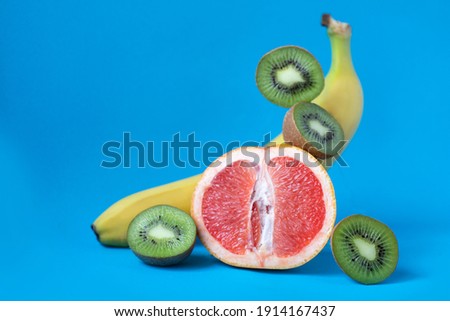 Fresh tropical fruits. Different fruits lie on a blue background. Useful vitamins. Banana, grapefruit, kiwi.