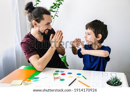 Happy autism boy during therapy with school counselor, learning and having fun together Royalty-Free Stock Photo #1914170926