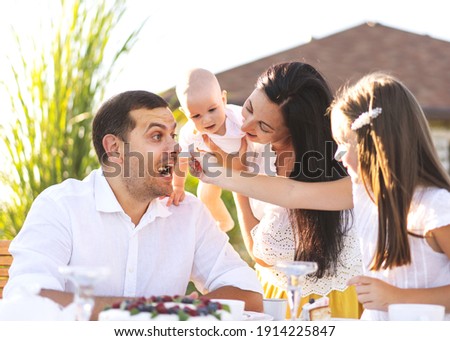 happy family at their backyard having picnic and tea party, hugging, family values