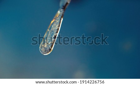 Macro shot of an icicle that looks like blown, melted glass or a Prince Rupert's drop. Shot outside on a cold winters day in the UK in February.