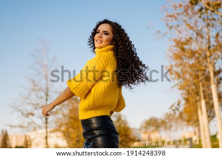 Girl whirls in park showing off her long curly hair flying beautifully in flight. High quality photo