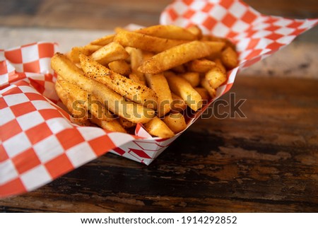 Close up of French Fries on a wooden table. Copy space. Shallow depth of field. Focus on the fries.