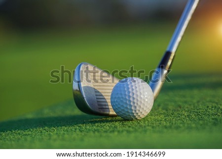 Golf club and ball in grass concept. Golf balls on the golf course with golf clubs ready for the first short. In the morning, with the beautiful sunlight. Royalty-Free Stock Photo #1914346699