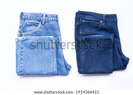 Blue jeans in a row, stack of denim pants, composition, denim texture. Royalty-Free Stock Photo #1914366415
