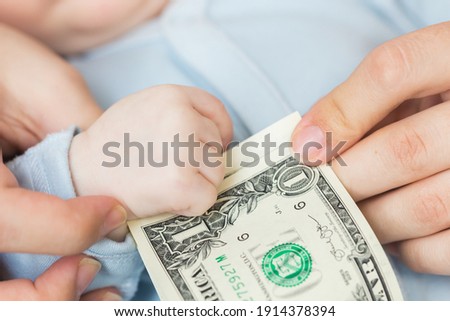 the one US dollar bill in the hand of a newborn child, the concept of paying a child's birth allowance, or the first salary of a person.