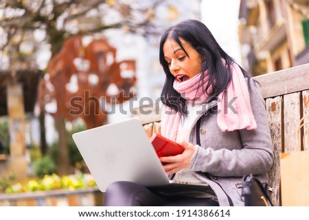 Surprise gift, Caucasian brunette girl opening the boyfriend's gift in a video call with the computer, separated by distance