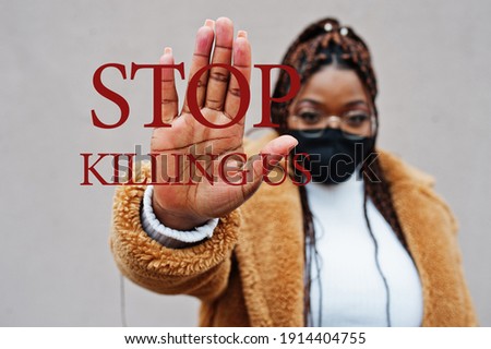 Stop killing us. African american woman, wear black face mask show stop hand sign. 