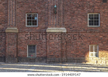 Brick wall in Stockholm. Interesting pattern of bricks. Beautiful texture and windows on the wall. Perfect geometry and lines