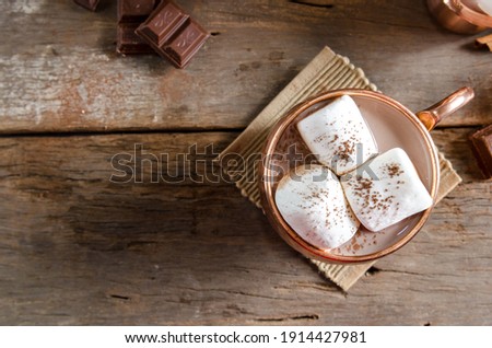 The dessert food vintage style : The Marshmallow with hot chocolate in copper cup on the wooden table. Background copy space for copy text
