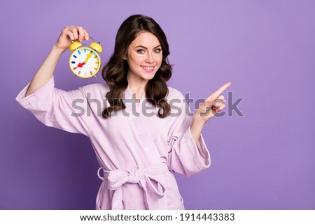Photo of young girl use eye patch show point finger empty space hold clock advert promo isolated over violet color background