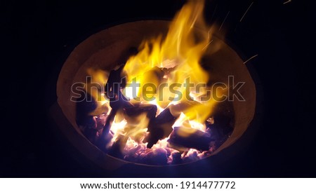 BBQ Grill Pit With Glowing And Flaming Hot Charcoal Briquettes,Fire charcoal in stove for cooking and grilling food or barbecue.Food Background Or Texture,Soft focus, Select focus 