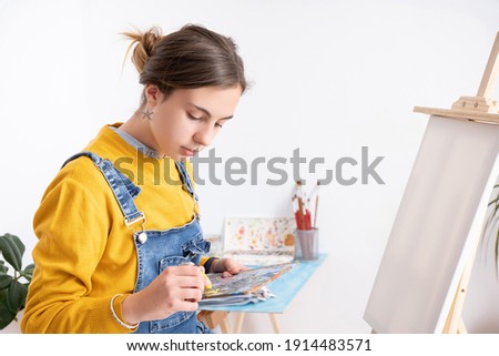 Woman pouring paint on painter's palette