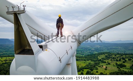 Female Inspection engineers standing on top of a wind turbine and looking beautiful  landscape
 Royalty-Free Stock Photo #1914483988
