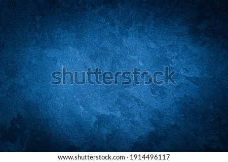 Blue decorative plaster texture with vignette. Abstract grunge background with copy space for design. Royalty-Free Stock Photo #1914496117