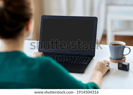 business, technology and people concept - woman with laptop computer working at home office