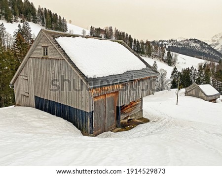 Idyllic old traditional Swiss mountain huts in a fresh snow cover over the Lake Walen or Lake Walenstadt (Walensee), Amden - Canton of St. Gallen, Switzerland (Schweiz)