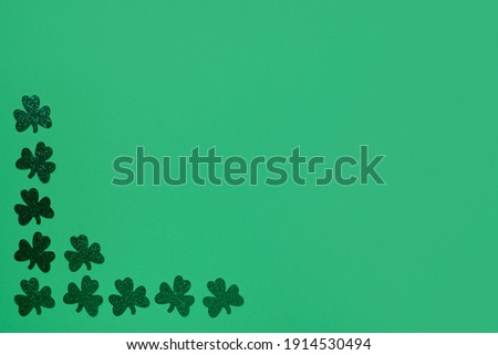 Concept of St. Patrick. Green clovers on green background, top view place for text.