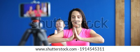 Man and woman do yoga and take training on phone. Relaxation and meditation techniques in yoga concept