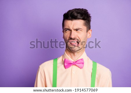 Photo of doubtful annoyed young guy wear yellow shirt looking empty space disgusting smell isolated violet color background