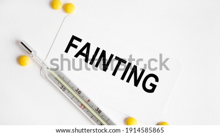On the business card tets FAINTING, next to the thermometer and yellow tablets.