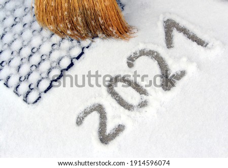 Snow and blizzard in February 2021. Broom at the front door of the house and drifts. Snow photography for printing in news, websites, magazines in Ukraine.