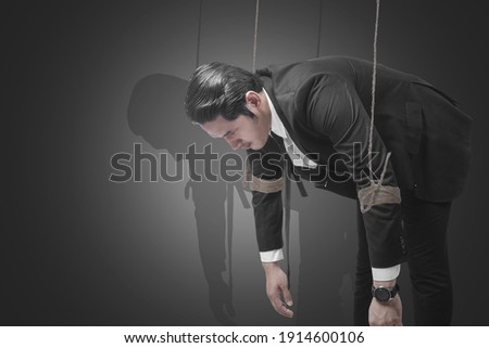 Asian businessman controlled with rope with a colored background
