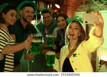 People with beer taking selfie in pub. St Patrick's day celebration
