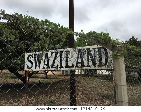 White tourist information signboard near local street at african border post gate with police control on holiday road trip on way to Kingdom of Eswatini, commonly known as Swaziland, South Africa.