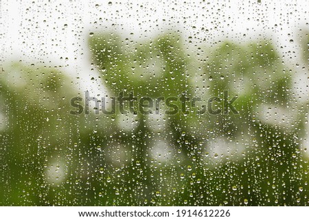 Raindrops on glass on a green background.Soft focus.Concept of sadness,bad mood.