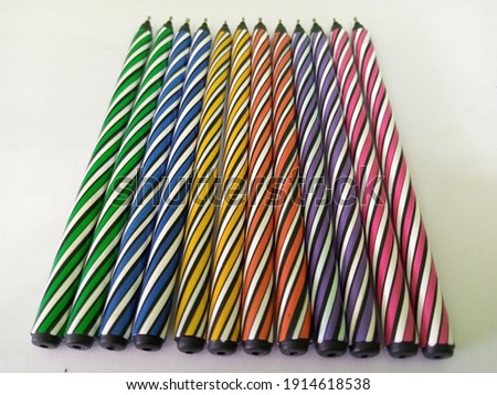 A set of colored pens arranged in a row