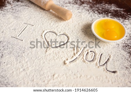 The inscription I love you on sprinkled flour, rolling pin and eggs. Baking recipes. Valentine's day concept. Declaration of love. Selective focus