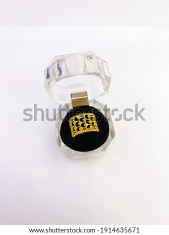 Beautiful gold ring in glass case on white background