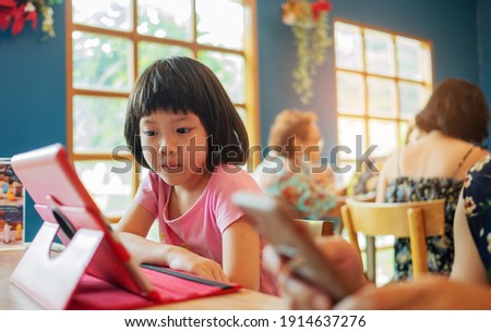 Kid watching tablet on the food table, children addicted cartoon
