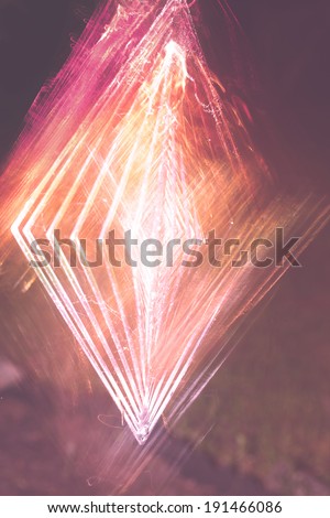 A colorful abstract of a garden wind spinner at night. Royalty-Free Stock Photo #191466086