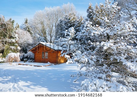 wooden house in the snow. Wooden garden shed covered with snow. First snow. Winter in the garden Royalty-Free Stock Photo #1914682168